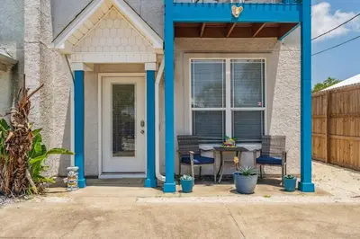 a blue house with a table and chairs on a patio at Beach Walkers by Beach Haven Vacation Rentals in Panama City Beach