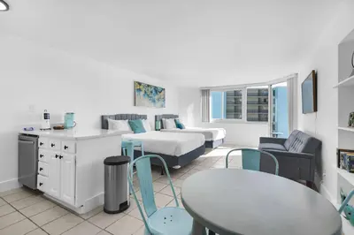 a living room with a bed and a table and chairs at Top of the Gulf 507 Beach Front Resort Ocean View in Panama City Beach