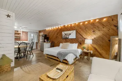 a bedroom with a bed and a living room at Cowboy Cottage by Beach Haven Vacation Rentals in Panama City Beach