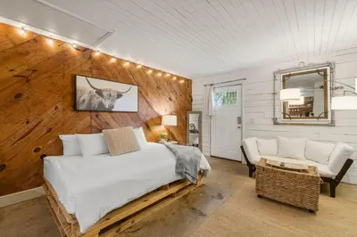 a bedroom with a bed and a couch at Cowboy Cottage by Beach Haven Vacation Rentals in Panama City Beach