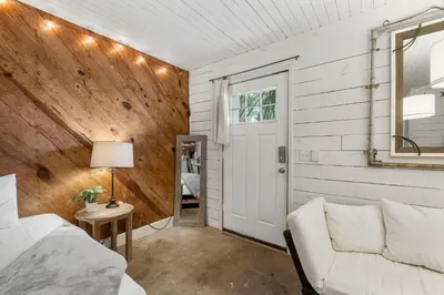 a room with a bed and a couch and a window at Cowboy Cottage by Beach Haven Vacation Rentals in Panama City Beach