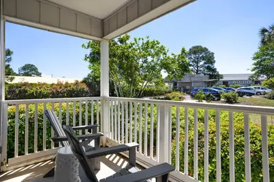 a rocking chair on a porch with a view of a street at Seagrove Siesta at Beachwood Villages - Walk to Beach Outdoor Pools & More in Santa Rosa Beach