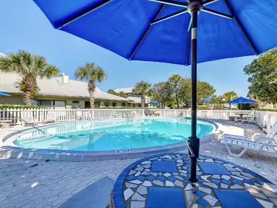 a blue umbrella sitting next to a swimming pool at Seagrove Siesta at Beachwood Villages - Walk to Beach Outdoor Pools & More in Santa Rosa Beach