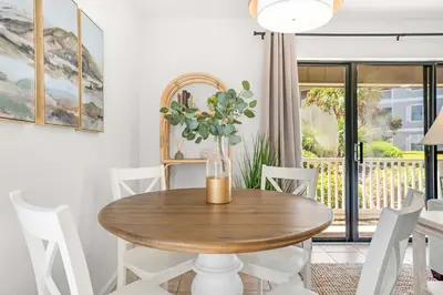 a dining room with a wooden table and white chairs at Seagrove Siesta at Beachwood Villages - Walk to Beach Outdoor Pools & More in Santa Rosa Beach