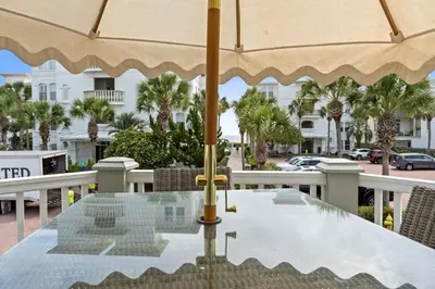 a table with an umbrella on top of a table at 30A Sunset Beach House - Villa Infinity by Panhandle Getaways in Seacrest