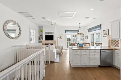 a kitchen and living room with white walls and wood floors at 30A Sunset Beach House - Villa Infinity by Panhandle Getaways in Seacrest
