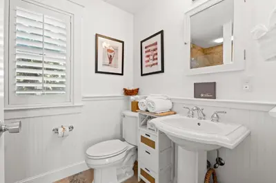 a white bathroom with a toilet and a sink at 30A Sunset Beach House - Villa Infinity by Panhandle Getaways in Seacrest