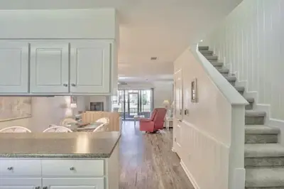a kitchen with a staircase and a living room at Dream Come True in PCB in Panama City Beach