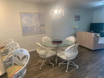a dining room with a glass table and chairs at Dream Come True in PCB in Panama City Beach