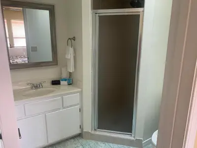 a bathroom with a shower with a sink and a mirror at Dream Come True in PCB in Panama City Beach