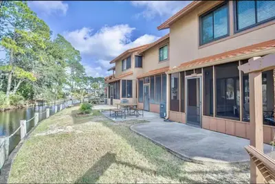 a house with a patio next to a river at Dream Come True in PCB in Panama City Beach