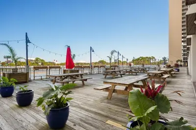 a deck with wooden picnic tables and potted plants at Laketown Wharf #1231 in Panama City Beach