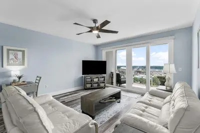 a living room with white furniture and a large window at Laketown Wharf #1231 in Panama City Beach