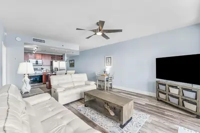 a living room with white furniture and a flat screen tv at Laketown Wharf #1231 in Panama City Beach