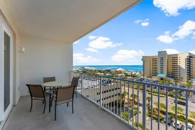 a balcony with a table and chairs and a view of the ocean at Laketown Wharf #0613 in Panama City Beach