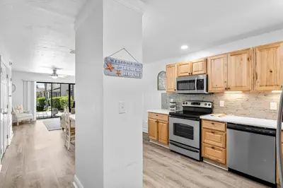 a kitchen with wooden cabinets and a stove top oven at Portside Resort AA1 by InJoy Vacations in Panama City Beach