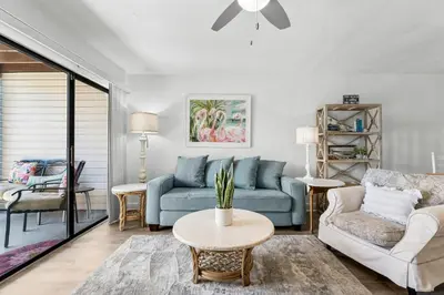 a living room with a blue couch and a table at Portside Resort AA1 by InJoy Vacations in Panama City Beach