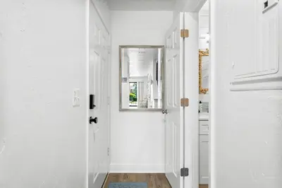 a white hallway with a mirror and a door at Portside Resort AA1 by InJoy Vacations in Panama City Beach
