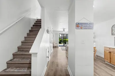 a white staircase in a home with white walls and wood floors at Portside Resort AA1 by InJoy Vacations in Panama City Beach