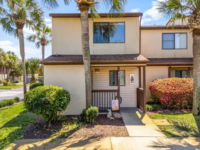 a house with palm trees in front of it at Portside Resort AA1 by InJoy Vacations in Panama City Beach