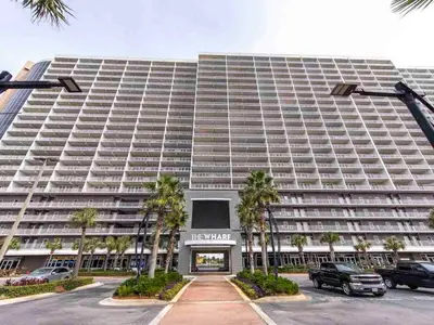 a large building with palm trees in front of it at Laketown Wharf #1137 in Panama City Beach