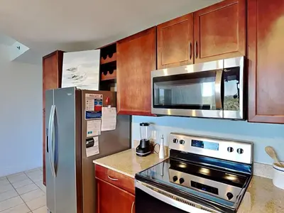 a kitchen with a stainless steel refrigerator and a microwave at Laketown Wharf #1137 in Panama City Beach