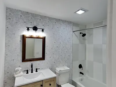 a bathroom with a sink and a toilet and a mirror at Salt & Sea A in Panama City Beach