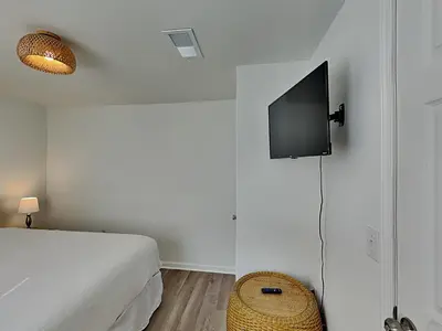 a bedroom with a bed and a tv on a wall at Salt & Sea A in Panama City Beach