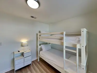a room with two bunk beds and a desk at Salt & Sea A in Panama City Beach