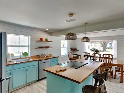 a kitchen with blue cabinets and a wooden table at Salt & Sea A in Panama City Beach
