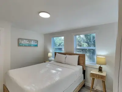 a bedroom with a large bed and two windows at Salt & Sea B in Panama City Beach