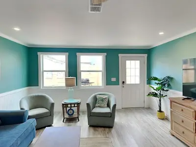 a living room with a couch and chairs and a tv at Salt & Sea B in Panama City Beach