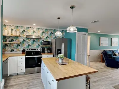a kitchen with white cabinets and a table in it at Salt & Sea C in Panama City Beach