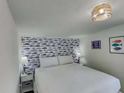 a bedroom with a white bed with a blue patterned wall at Salt & Sea C in Panama City Beach