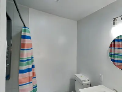 a bathroom with a shower curtain and a mirror at Salt & Sea C in Panama City Beach