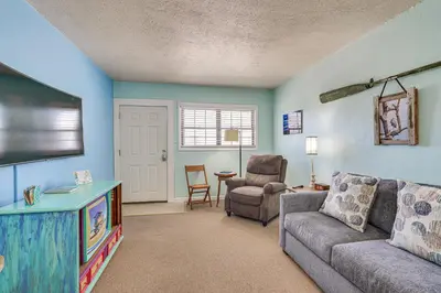 a living room with a couch and a flat screen tv at Steps to Sand Panama City Beach Apartment! in Panama City Beach