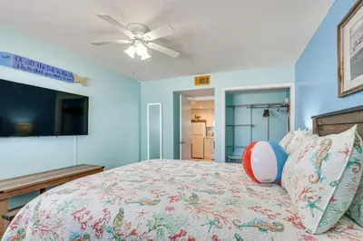 a bedroom with a bed and a ceiling fan at Steps to Sand Panama City Beach Apartment! in Panama City Beach