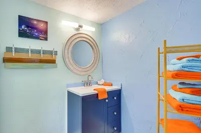 a bathroom with a sink and a mirror and towels at Steps to Sand Panama City Beach Apartment! in Panama City Beach