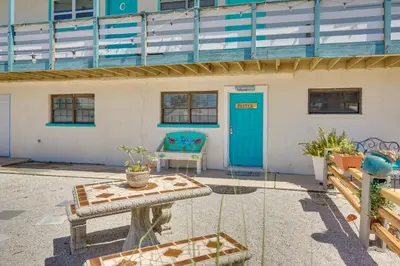 a building with a blue door and a bench at Steps to Sand Panama City Beach Apartment! in Panama City Beach
