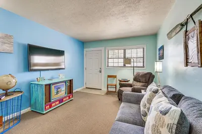 a living room with a couch and a tv at Steps to Sand Panama City Beach Apartment! in Panama City Beach