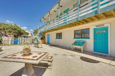 a building with a blue door and a bench at Steps to Sand Panama City Beach Apartment! in Panama City Beach