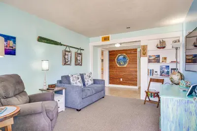 a living room with a couch and a chair at Steps to Sand Panama City Beach Apartment! in Panama City Beach