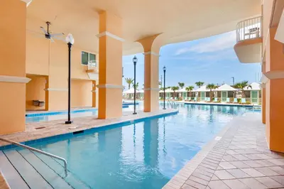 a swimming pool at a resort with blue water at Calypso 3-2112 by Emerald Coast Retreats in Panama City Beach