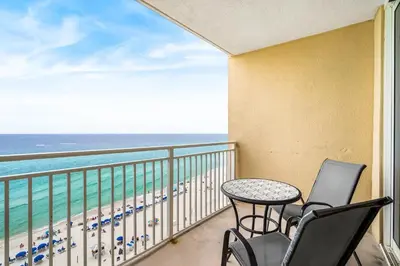 a balcony with a table and chairs and the ocean at Emerald Beach Resort 1133 - Beachfront with Breathtaking Views by Beach Haven Vacation Rentals in Panama City Beach