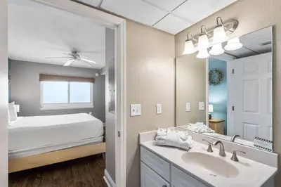 a bathroom with a sink and a bed and a mirror at Emerald Beach Resort 1133 - Beachfront with Breathtaking Views by Beach Haven Vacation Rentals in Panama City Beach