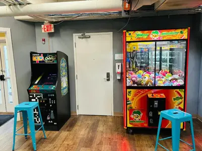 a room with two arcade games and two stools at Emerald Beach Resort 1133 - Beachfront with Breathtaking Views by Beach Haven Vacation Rentals in Panama City Beach
