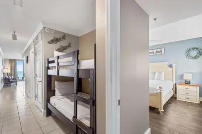 a bedroom with two bunk beds and a hallway at Emerald Beach Resort 1133 - Beachfront with Breathtaking Views by Beach Haven Vacation Rentals in Panama City Beach