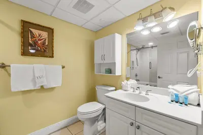 a bathroom with a toilet and a sink and a mirror at Emerald Beach Resort 1834 - Beachfront with Stunning Views by Beach Haven Vacation Rentals in Panama City Beach