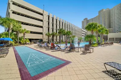 a resort with a pool and chairs and palm trees at Emerald Beach Resort 1834 - Beachfront with Stunning Views by Beach Haven Vacation Rentals in Panama City Beach