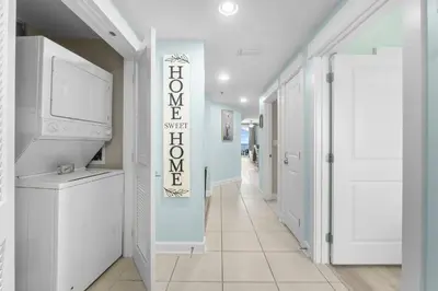 a hallway with white walls and a sign that says welcome at Grand Panama 1005 - Tower Two - 2 bedroom - Large Deck with Gulf Views by Beach Haven Vacation Rentals in Panama City Beach